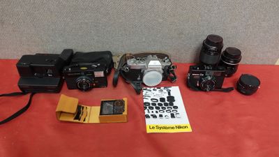 a group of cameras sitting on top of a table next to a book