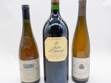 trois bouteilles de vin posées l'une à côté de l'autre sur une table