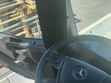 a steering wheel of a truck with a bunch of wooden pallets in the background