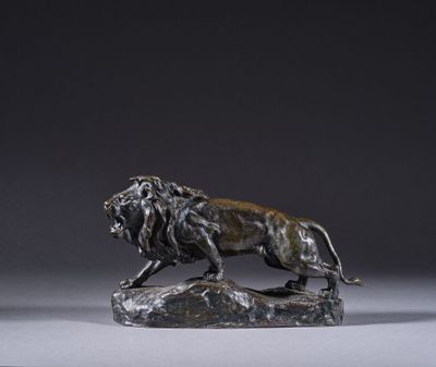 statue en bronze représentant un lion perché sur un rocher, sur fond gris