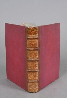 un vieux livre à la couverture rouge posé sur une table