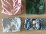 trois paires de vêtements pour bébé disposées sur un parquet