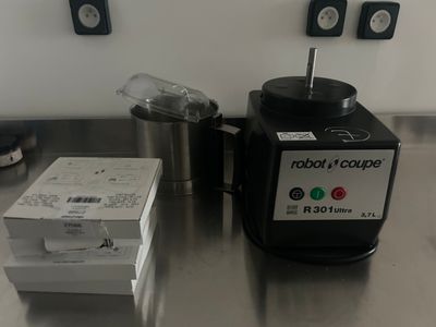 un mixeur posé sur une table à côté d'une boîte de provisions