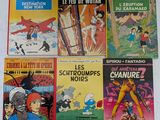 Plusieurs bandes dessinées sont alignées sur une surface blanche