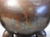 a large metal pot sitting on top of a wooden stand