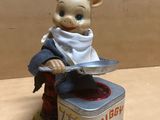 a figurine of a pig in a chef ' s hat holding a knife