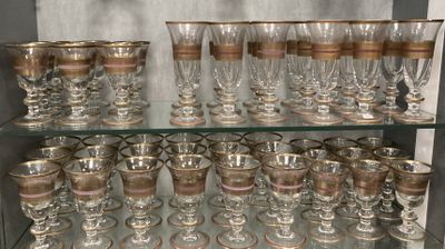 a glass shelf with many glasses on it