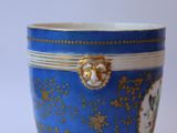 a blue cup with a gold decoration on it