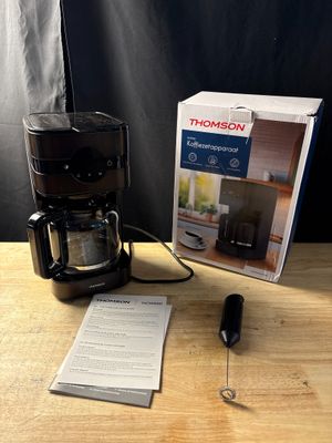 une cafetière posée sur une table à côté d'une boîte
