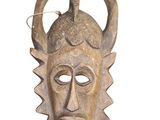 an image of a wooden mask with a horned head on a white background