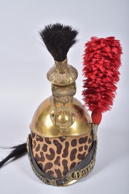 a gold helmet with a red feather on top of it