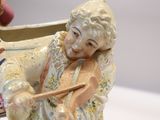 a figurine of a man playing a violin
