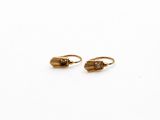 une paire de boucles d'oreilles en or sur fond blanc