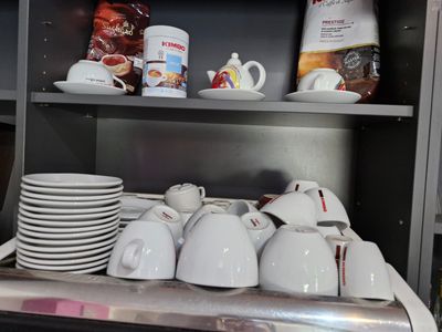 many cups and mugs on a shelf in a kitchen