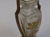 a glass vase with a gold decoration on it