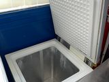 un petit réfrigérateur posé dans un coin de la cuisine