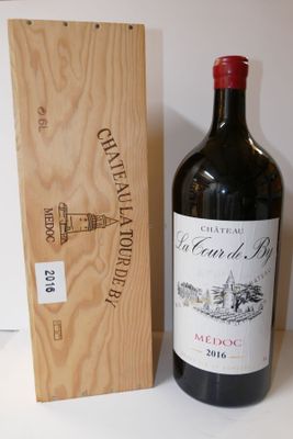 une bouteille de vin posée à côté d'une caisse en bois
