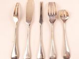 four forks and a knife on a white surface