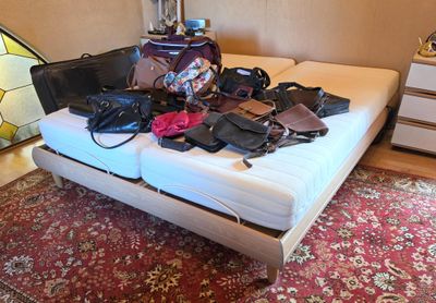 an image of a bed with a lot of bags on it