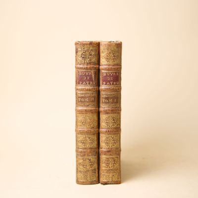 deux vieux livres posés l'un sur l'autre sur une surface blanche