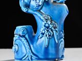 a blue vase with a bird on it on a table