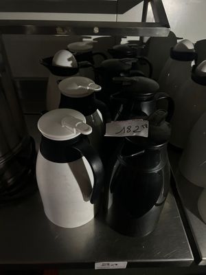 a lot of coffee pots and cups on the counter