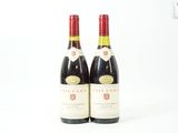 deux bouteilles de vin rouge posées l'une à côté de l'autre sur une surface blanche