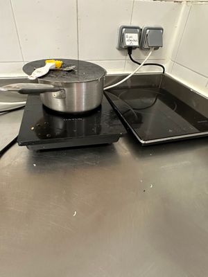 une casserole et une poêle posées sur la plaque de cuisson d'une cuisine