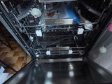 an empty dishwasher in the middle of a kitchen