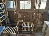 two wooden chairs sitting in a room with a window