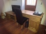 a desk with a computer and a chair in the room