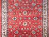 a red rug with a floral design on a white background