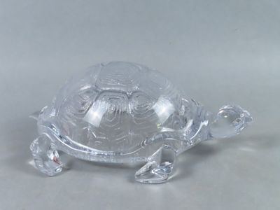 une figurine de tortue en verre posée sur une table