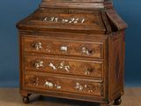 une vieille commode en bois ornée d'un motif représentant un cheval sur la façade