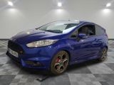une ford fiesta bleue garée sur un sol en damier dans un garage