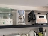 une étagère de cuisine sur laquelle se trouvent un mixeur, une cafetière et d'autres ustensiles de cuisine