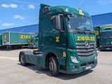 a green truck that is parked in front of a building