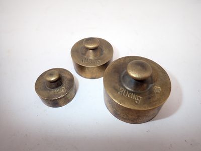 trois boutons en laiton vieilli sur une surface blanche