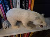 a polar bear that is standing on a book shelf