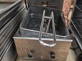 une grande friteuse posée sur un plan de travail dans une cuisine