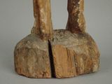 a wooden statue of a person standing on a rock