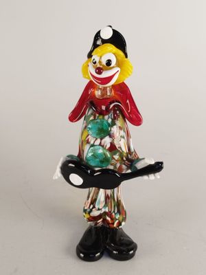 figurine of a clown holding a tray of candy on a white background