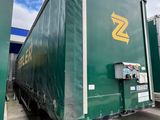 un semi-remorque vert garé sur un parking