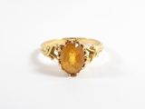 Gros plan sur une bague en or avec une pierre orange