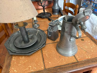une table sur laquelle se trouvent une lampe, une assiette et un vase