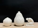 three white vases sitting on a table next to each other