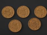 four gold sovereigns of different sizes and shapes on a black surface