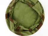 a close up of a green and brown hat on a white surface