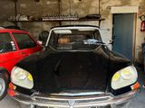 une voiture noire garée dans un garage à côté d'une voiture rouge