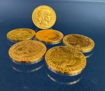 quatre pièces d'or empilées les unes sur les autres sur un fond bleu